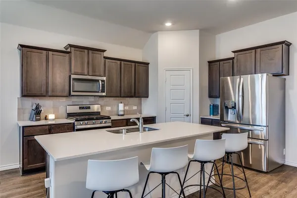 a kitchen with stainless steel appliances granite countertop a stove microwave and sink