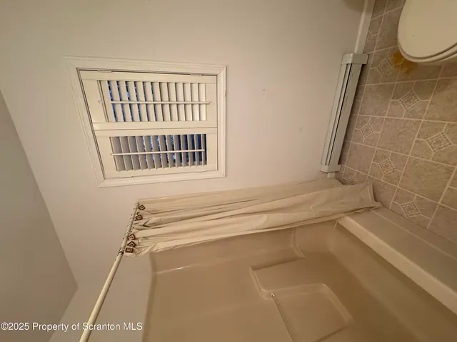 a bathroom with a window and a shower