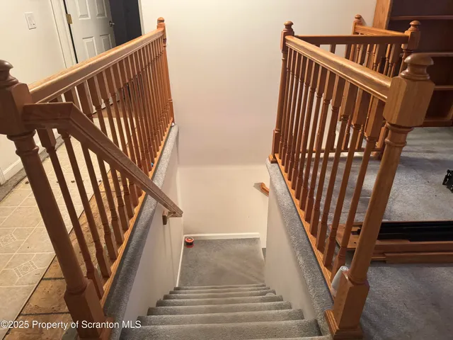 a view of staircase with railing and white walls