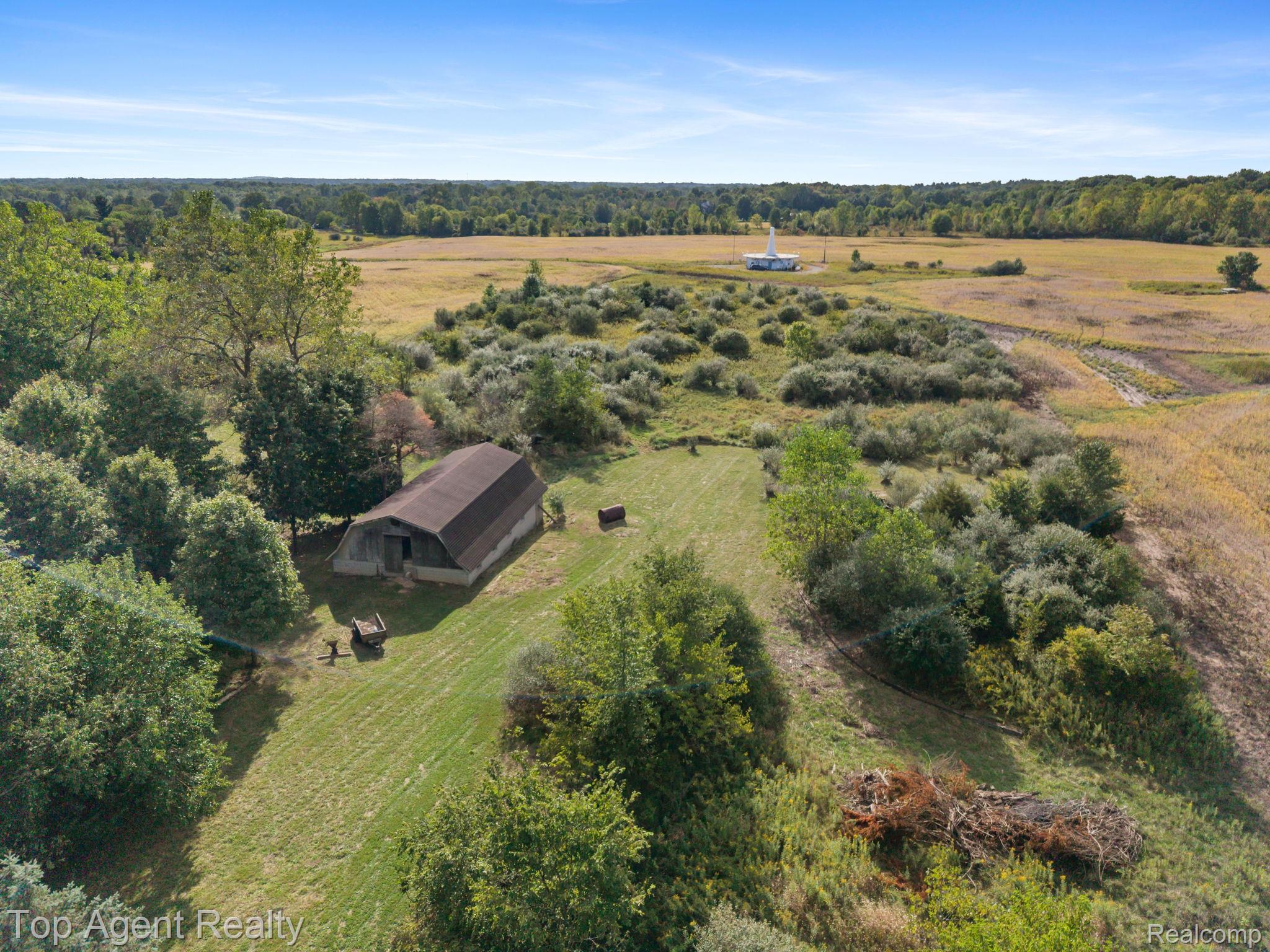 8269 Currie Road Northville, MI 48168 - Photo 77 of 80 Barn structure featuring a gambrel roof and adjacent grassy areas
