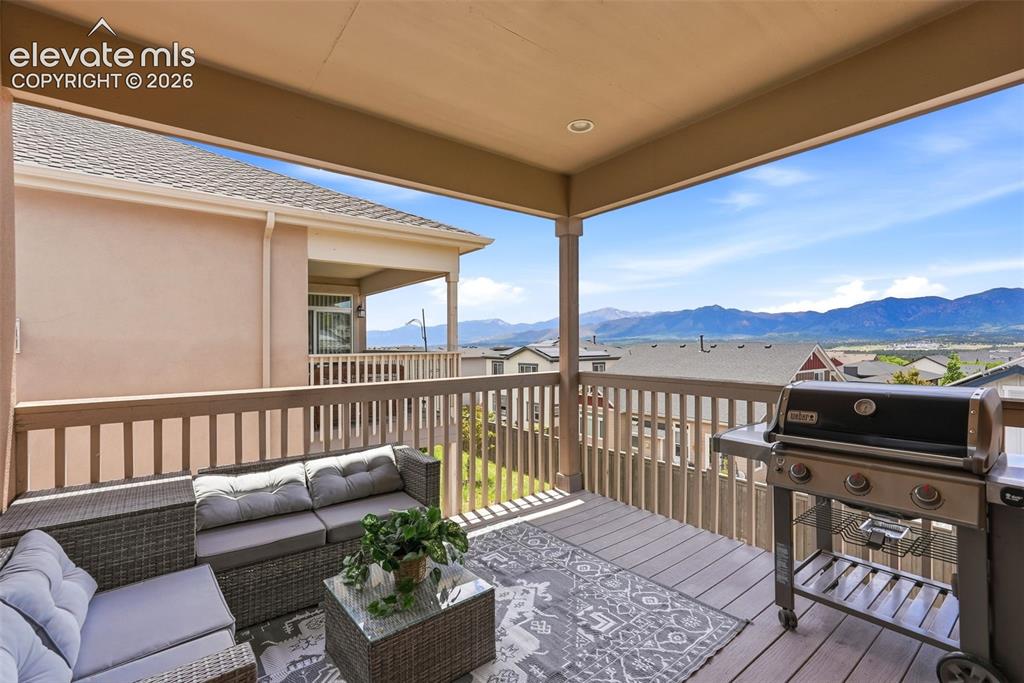 1394 Promontory Bluff View Colorado Springs, CO 80921 - Photo 18 of 47 a balcony with furniture and a floor to ceiling window