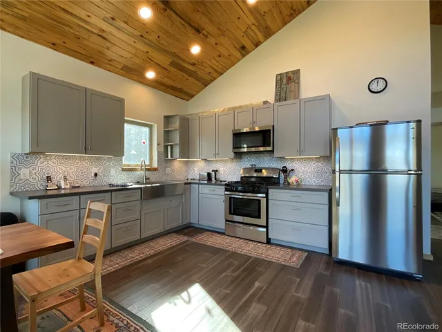 a kitchen with stainless steel appliances granite countertop a refrigerator stove microwave and sink