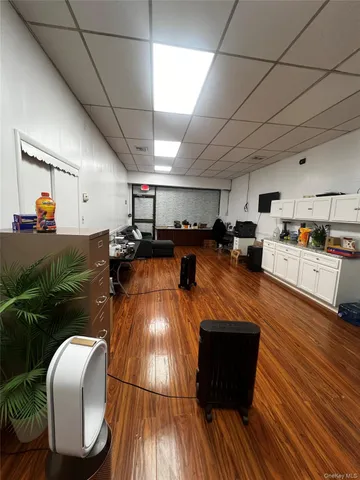 a living room with stainless steel appliances furniture and a kitchen view