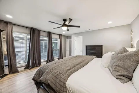a spacious bedroom with a large bed and a ceiling fan
