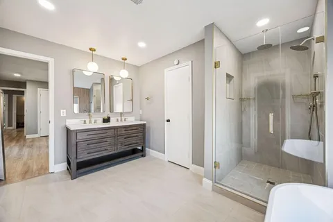 a bathroom with a double vanity sink mirror and shower