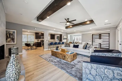 a living room with furniture kitchen view and a wooden floor