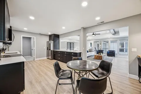 a kitchen with sink refrigerator dining table and chairs