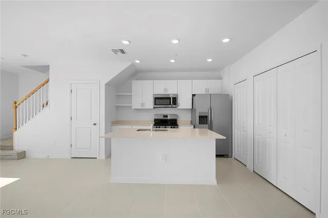 a view of kitchen with stainless steel appliances refrigerator stove microwave and refrigerator