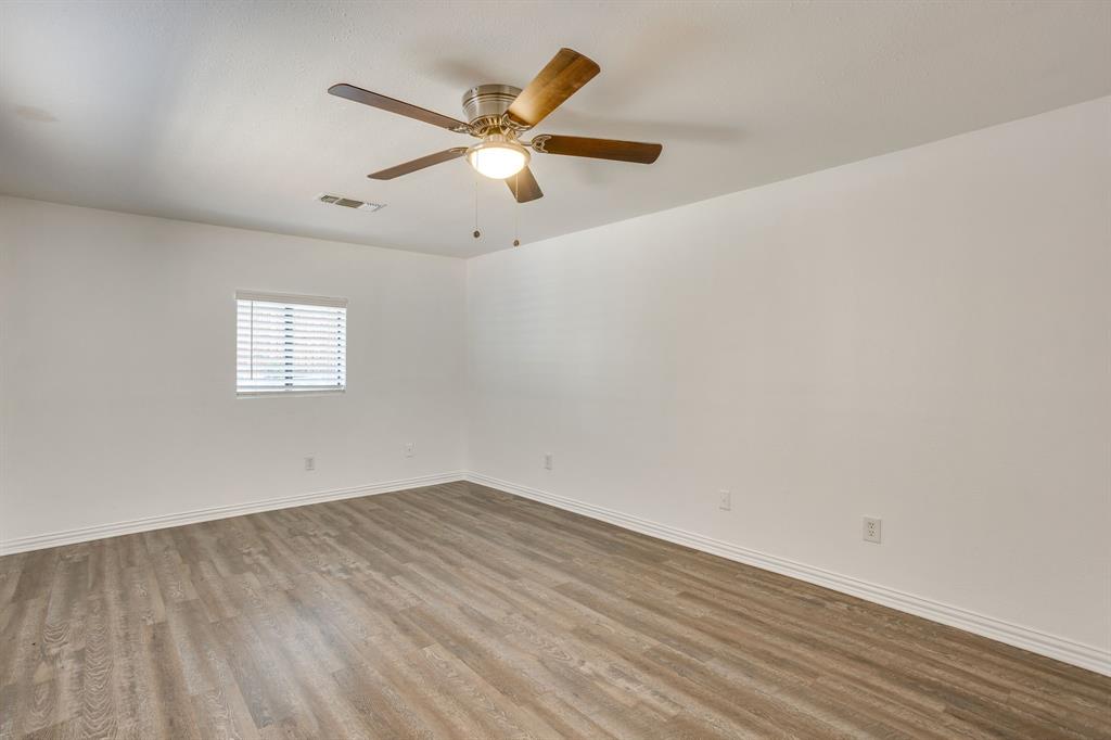 6940 Hatch Road Fort Worth, TX 76135 - Photo 21 of 40 Spacious room featuring wood-finish flooring, white walls, and a ceiling fan with integrated lighting