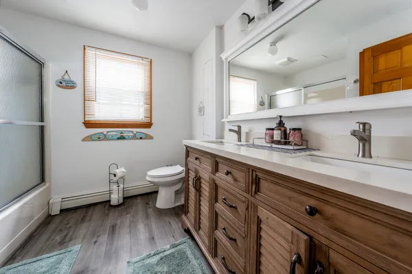 a spacious bathroom with a double vanity sink a toilet and a window