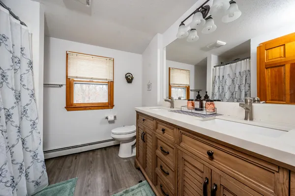 a spacious bathroom with a granite countertop sink toilet and a mirror