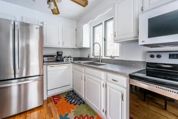 a kitchen with a refrigerator stove and white cabinets