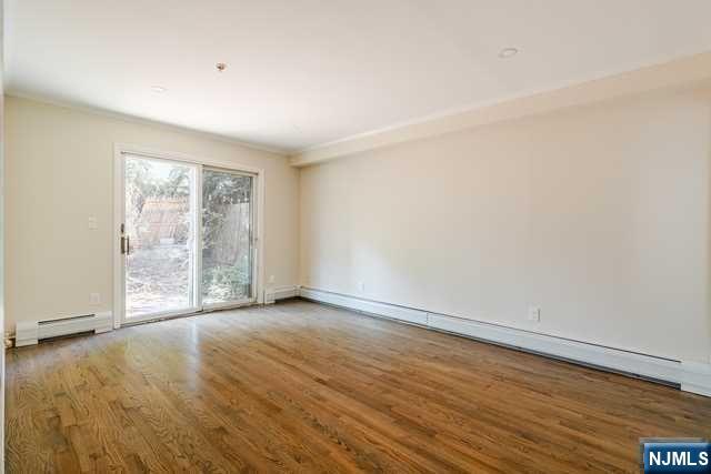 57 71st Street Guttenberg, NJ 07093 - Photo 14 of 18 wooden floor in an empty room with a window