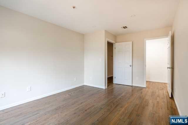 57 71st Street Guttenberg, NJ 07093 - Photo 17 of 18 a view of an empty room with wooden floor