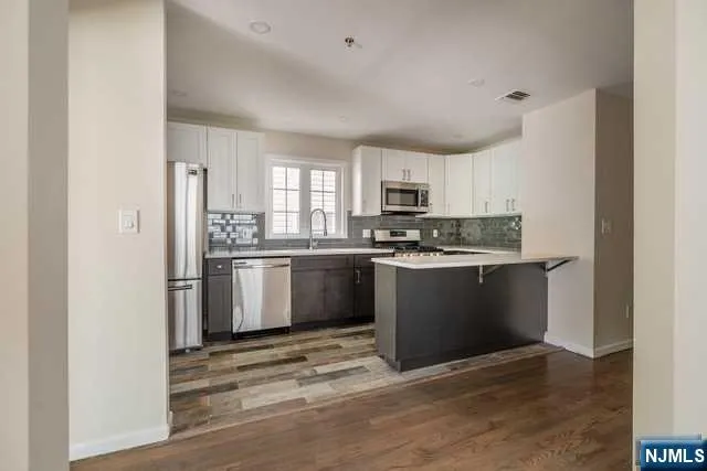 a kitchen with a refrigerator stove top oven and sink