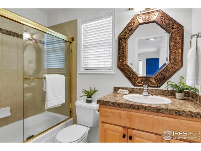 a bathroom with a granite countertop sink a mirror and shower