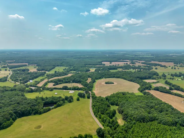 an aerial view of ocean with residential houses with outdoor space and swimming pool