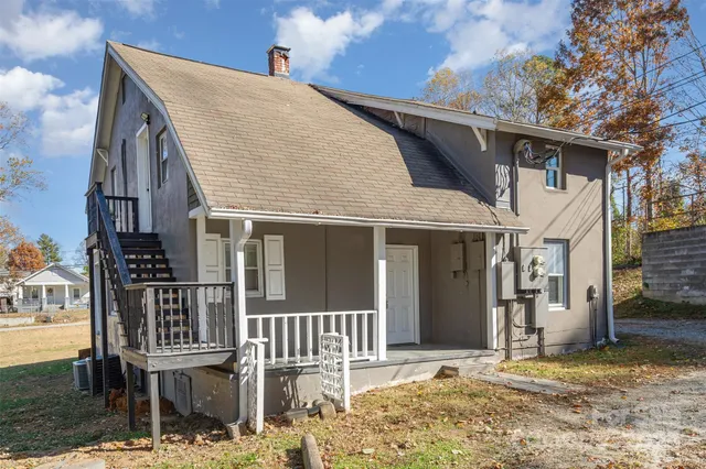 a view of a house with a door and wooden fence