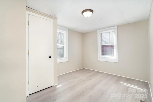 an empty room with windows and closet