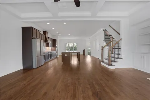 a view of a living room and kitchen with a large window stainless steel appliances