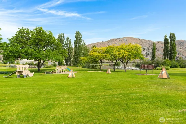 a view of a house with a big yard and large trees