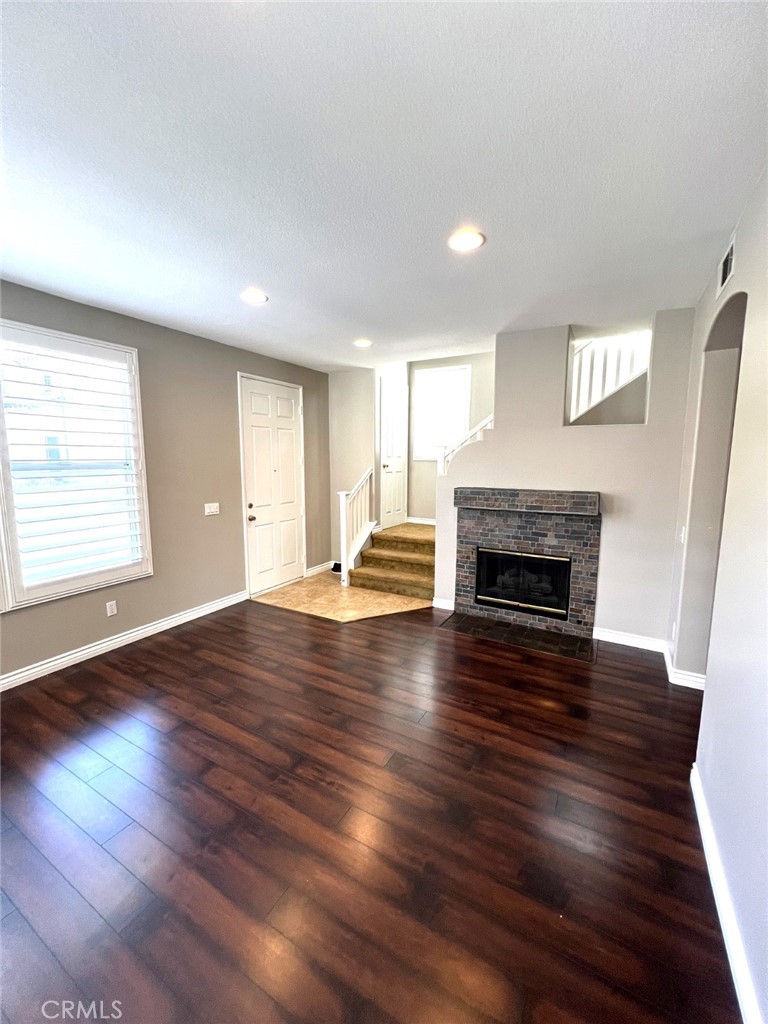 14101 Visions Drive La Mirada, CA 90638 - Photo 8 of 26 an empty room with wooden floor fireplace and windows