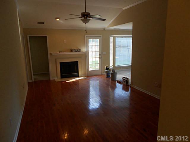 906 Treasure Place Southwest Concord, NC 28025 - Photo 2 of 15 a view of a livingroom with wooden floor a fireplace and window