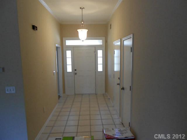 906 Treasure Place Southwest Concord, NC 28025 - Photo 3 of 15 a view of a hallway with wooden floor and a chandelier