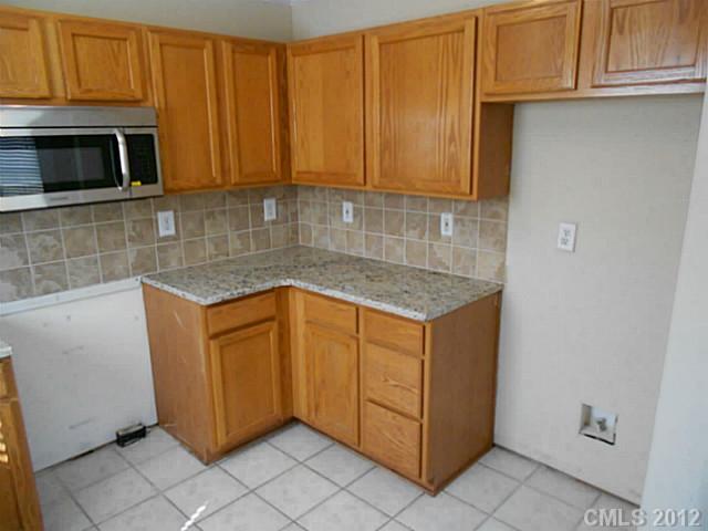 906 Treasure Place Southwest Concord, NC 28025 - Photo 6 of 15 a kitchen with granite countertop cabinets stainless steel appliances and a counter space