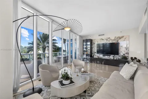 a living room with furniture a flat screen tv and a floor to ceiling window