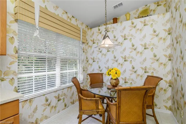 a view of a dining room and livingroom with furniture a chandelier and window