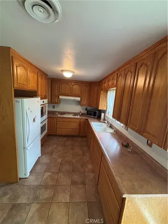 a kitchen with stainless steel appliances granite countertop a refrigerator and a stove top oven