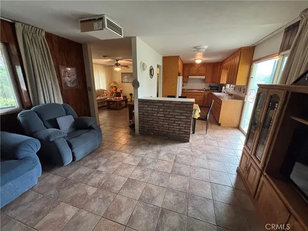 a living room with couches chairs and kitchen view
