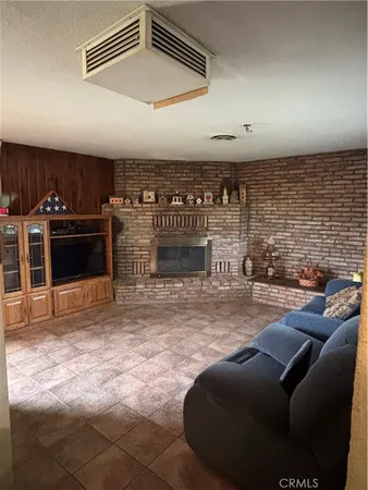 a living room with furniture a fireplace and kitchen view