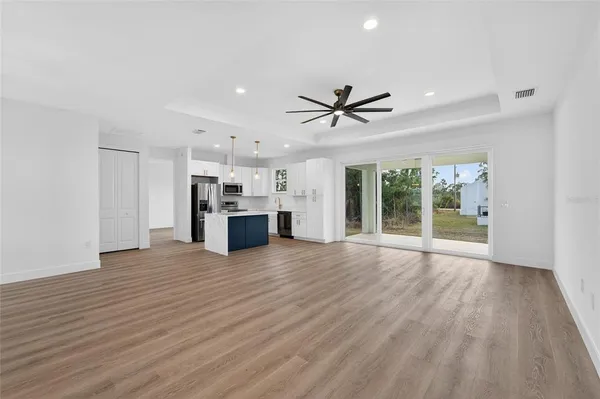 a view of empty room with wooden floor and ceiling fan