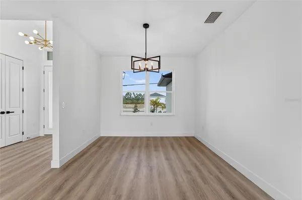 a large kitchen with a wooden floor and a ceiling fan