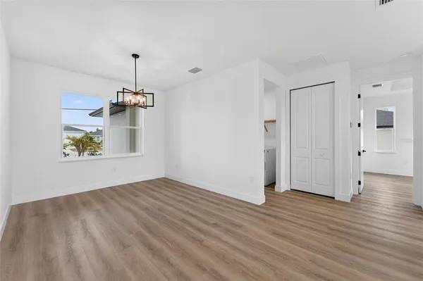 a large kitchen with a wooden floor and a ceiling fan