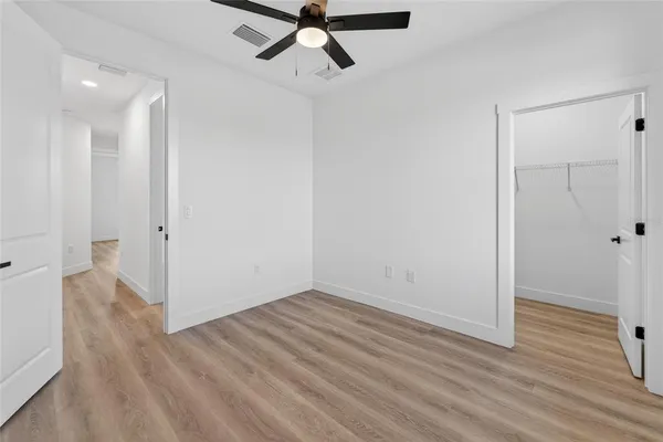a view of a hallway with a ceiling fan