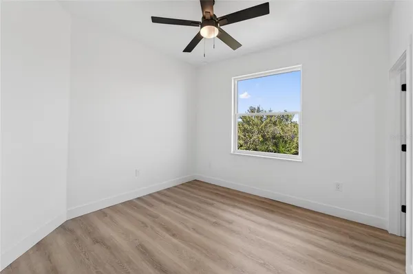 a very nice looking room with a large window and ceiling fan