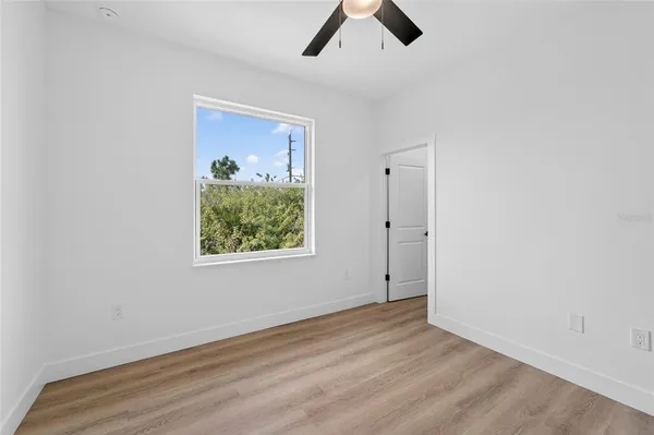 a view of a house with a big yard potted plants and a large window