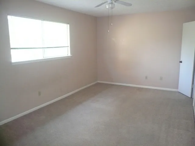 an empty room with windows and closet