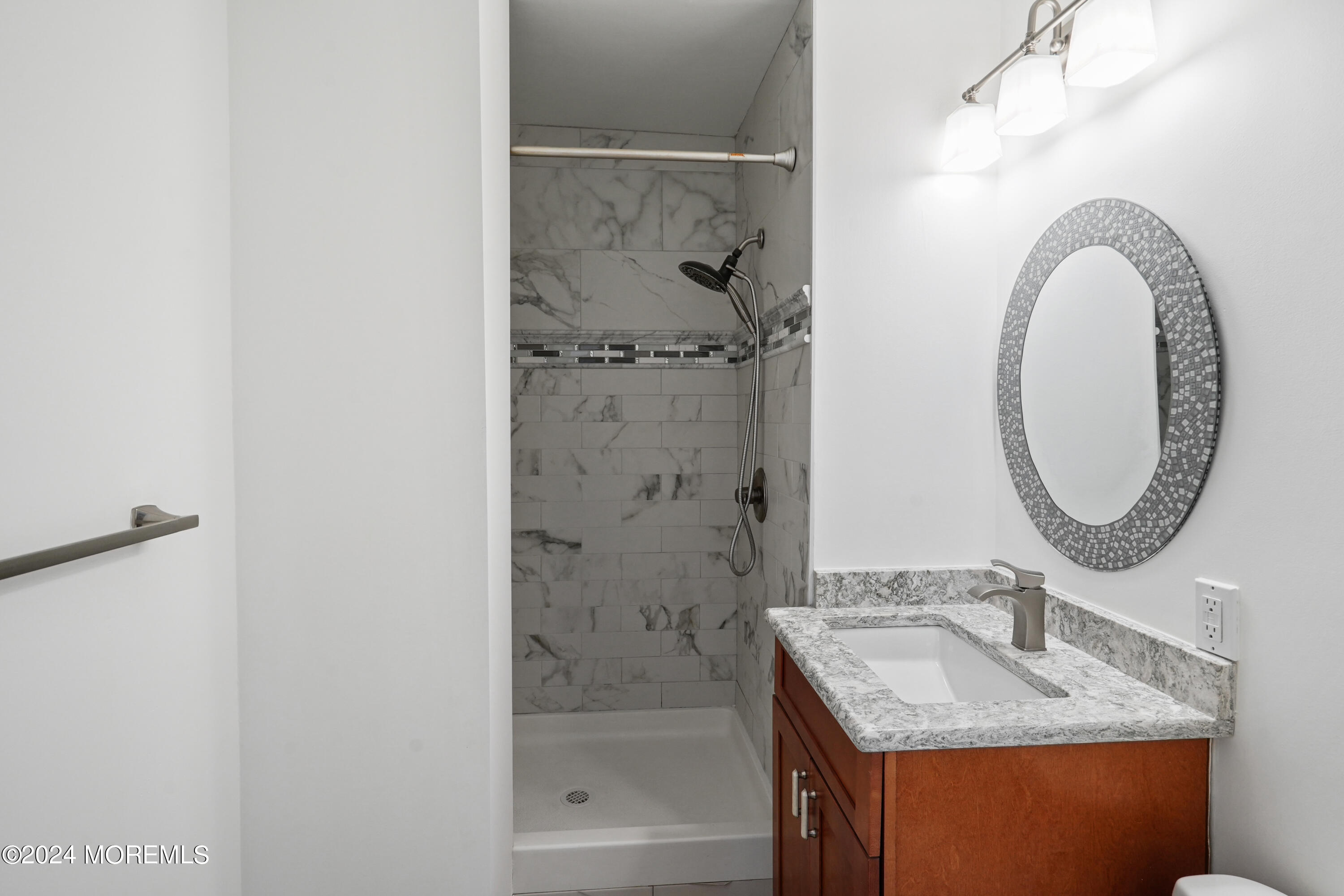 28 Riverside Avenue, Unit 8N Red Bank, NJ 07701 - Photo 15 of 30 a bathroom with a granite countertop sink a mirror and shower
