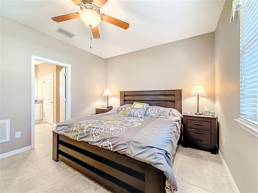 5647 Northwest 37th Lane Road Ocala, FL 34482 - Photo 12 of 50 a bedroom with a bed and a chandelier