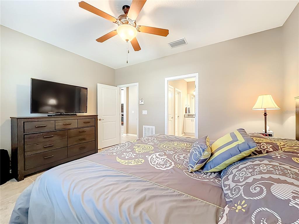 5647 Northwest 37th Lane Road Ocala, FL 34482 - Photo 13 of 50 a bedroom with a bed and a flat screen tv