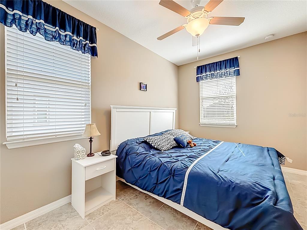 5647 Northwest 37th Lane Road Ocala, FL 34482 - Photo 16 of 50 a bedroom with a bed and a chandelier