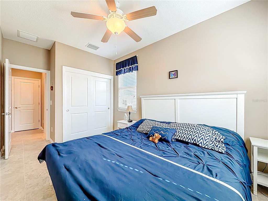 5647 Northwest 37th Lane Road Ocala, FL 34482 - Photo 17 of 50 a bedroom with a bed and a chandelier