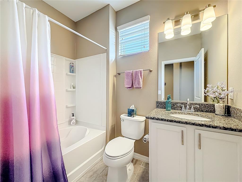 5647 Northwest 37th Lane Road Ocala, FL 34482 - Photo 18 of 50 a bathroom with a granite countertop sink mirror vanity and toilet