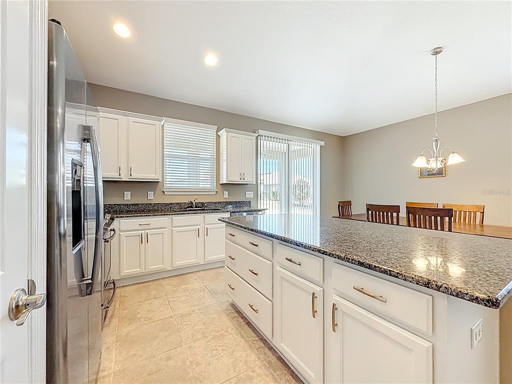 5647 Northwest 37th Lane Road Ocala, FL 34482 - Photo 3 of 50 a kitchen with granite countertop white cabinets and white appliances