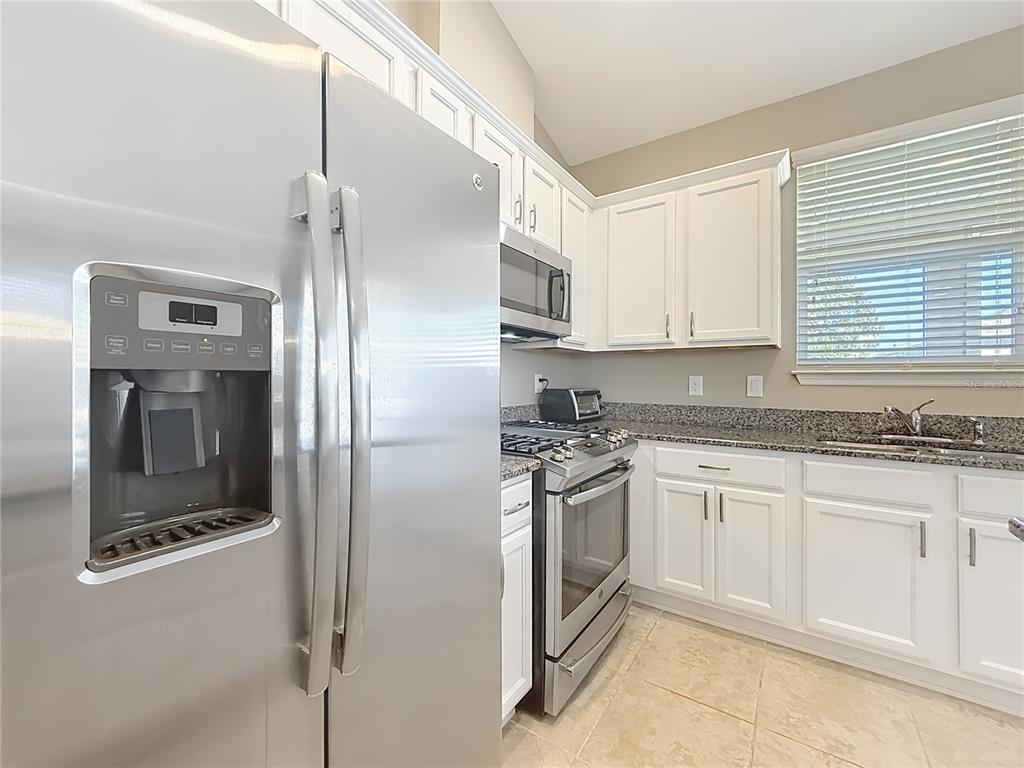 5647 Northwest 37th Lane Road Ocala, FL 34482 - Photo 4 of 50 a kitchen with stainless steel appliances granite countertop a stove a refrigerator and a sink