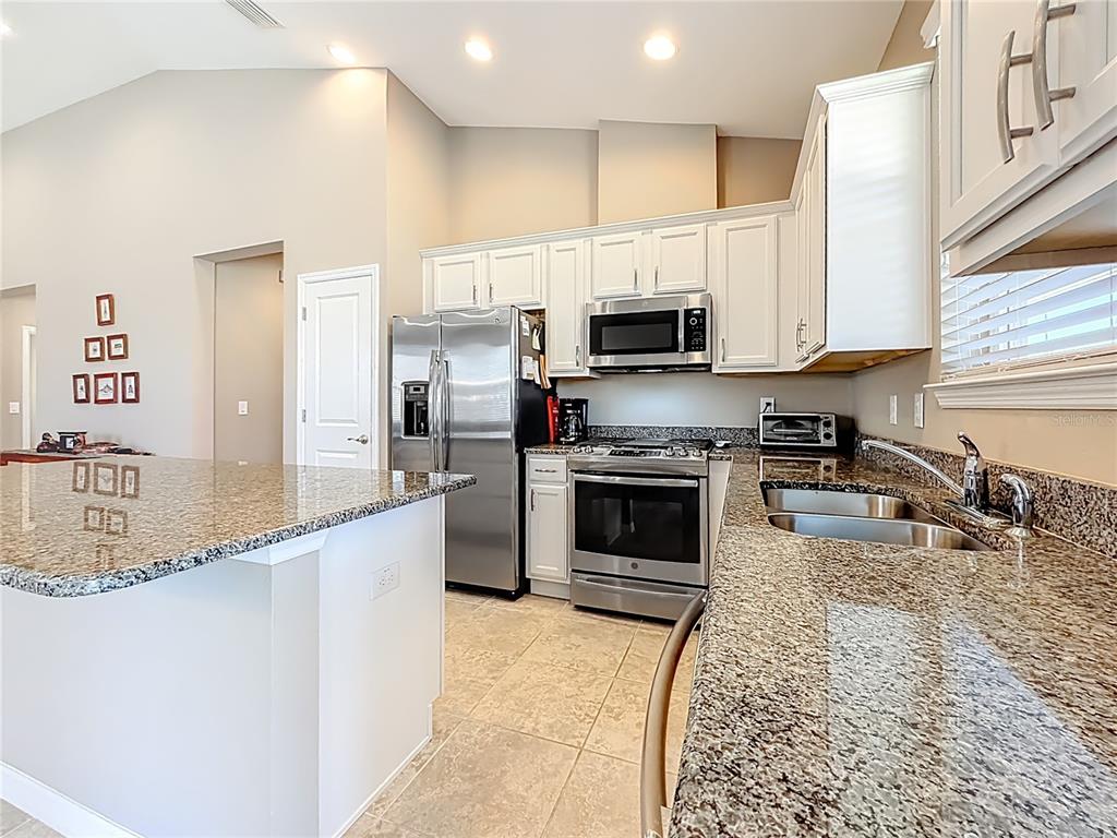5647 Northwest 37th Lane Road Ocala, FL 34482 - Photo 7 of 50 a kitchen with stainless steel appliances granite countertop a sink a stove top oven a counter space and cabinets